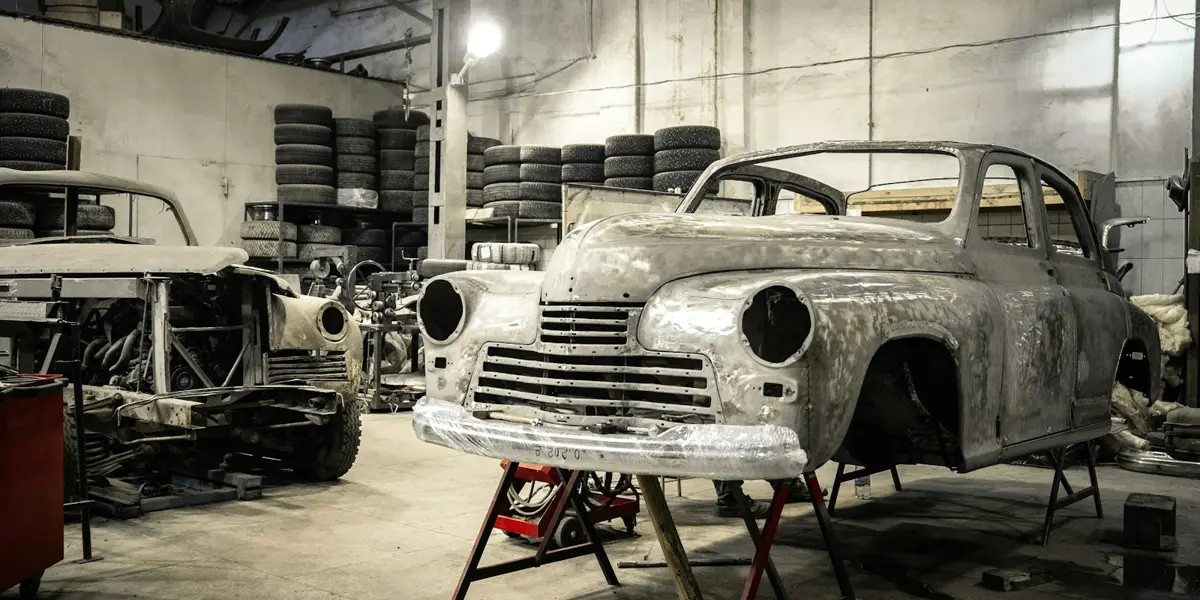 Classic cars under restoration in a workshop, the subject of a car-history YouTube channel